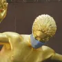Masked Prometheus gilded statue with an arm raised and holding a golden object.