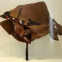 Dynamism of a Speeding Horse + Houses sculpture with angular brown, red, black, and white planes on a dark stand.