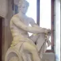 Ludovisi Ares seated with a shield beside him and a small winged figure near his leg.
