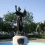Russell Alger Memorial Fountain with a helmeted female figure holding a shield and sword atop a stone pedestal in a fountain basin.