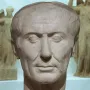 Tusculum portrait of Julius Caesar, a weathered marble bust with a receding hairline and lined face.
