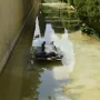 Ophelia Drowned sculpture lying on a submerged base in a shallow green-tinged water channel