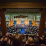 Sacred Cod fish sculpture hanging in a legislative chamber with rows of seated people