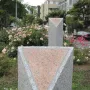 Pink Triangle Park memorial with two gray granite columns topped by pink triangles, set among grass and roses.