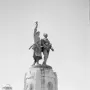 Demba et Dupont monument showing two military figures atop a tall stone pedestal with plaques and inscriptions.