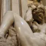 Michelangelo’s Night, a reclining nude marble figure with an owl and mask on the base.