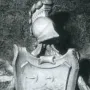 Coat of arms on the Tomb of Ferdinand van den Eynde, with a shield flanked by swan-like figures and topped by a classical helmet crest.