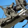 Bronze horsemen statues from the Vargas Swamp Lancers monument against a blue sky.
