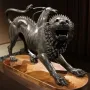 The Chimera of Arezzo, a bronze sculpture of a lion with a goat’s head on its back and a serpent tail, shown in a lunging pose.