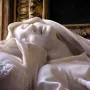 Close-up of Bernini’s Ecstasy of Blessed Ludovica Albertoni, showing the recumbent marble figure’s face, drapery, and carved pillow.