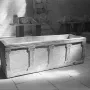 Sarcophagus of Louis the German, a rectangular stone chest with carved pilasters and Ionic-style capitals inside a museum space.