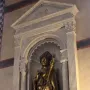 Golden statue of Saint Louis of Toulouse in a carved stone niche with columns and a shell-shaped arch.