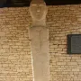 U Nativu stone bust against a dry-stone wall