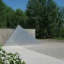 Hailfingen-Tailfingen Memorial with a textured triangular metal sculpture in front of a concrete wall.