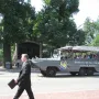 The Shaw Memorial appears behind trees and a stone wall, with a Boston Duck Tours vehicle passing in front.