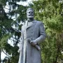 Bronze monument to Hristo Botev showing a bearded man in a long coat holding a rolled document.