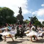 José de San Martín equestrian statue above dancers in traditional dress performing in a park
