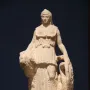 Lenormant Athena, a marble statue of a helmeted draped female figure holding a rounded object and a coiled serpent-like form