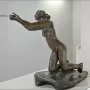 The Implorer bronze sculpture of a nude woman kneeling with outstretched arms.