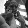 Stone sculpture of Ugolino and His Sons showing a man in intense anguish with his hands gripping his mouth.