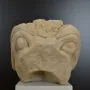Stone head of the Grifo de Redován with rounded eyes and ornate carved details on the forehead and top surface.