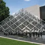 Delta Solar sculpture with reflective triangular panels rising above a dark pool of water.