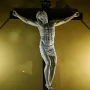 Benvenuto Cellini crucifix showing a white marble Christ figure on a dark wooden cross with INRI at the top.