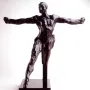 Standing Mercury, a dark bronze nude male sculpture posed with one leg lifted and both arms extended.