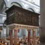 The Passion Pulpit with intricate relief sculptures on a dark rectangular pulpit supported by four marble columns.