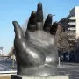 Botero’s Hand sculpture rising from a pedestal on a grassy median in Madrid