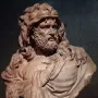 Clay bust of Hercules with a fur pelt draped over his shoulders and a bearded, determined face.