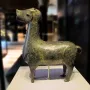 Stylized metallic deer sculpture from Madinat al Zahra on a white pedestal.