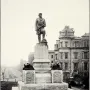 Admiral David G. Farragut statue atop a tall stone pedestal with naval decorations in a park setting.