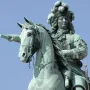 Upper portion of the Equestrian Statue of Louis XIV, showing the rider with a feathered hat and baton on horseback.