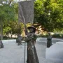 Virginia Women’s Monument sculpture with a central figure holding a tall Votes for Women banner, with additional statues on a stone patio behind it.