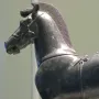 Bronze horse sculpture from a quadriga, shown in profile with a ridged mane and harness details.