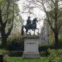 William III equestrian statue on a tall pedestal in a green park, with buildings in the background.