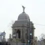 Hurlbut Memorial Gate with a domed stone structure, arched openings, and columns behind a wire fence