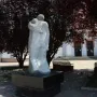 The Shot in the Back monument showing two figures embracing, one carrying the other on its back, on a dark base outdoors.