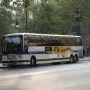Simón Bolívar Equestrian Statue partially obscured by a large bus in front of trees.
