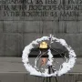 Unknown Soldier Monument with a granite memorial wall, Cyrillic inscriptions, and an eternal flame in a circular basin.