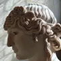Left-side profile of the Antinous Mondragone marble head with wavy hair and a calm expression.