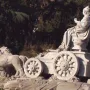 Cibeles Fountain sculpture with a crowned figure seated in a chariot pulled by two lions.