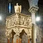 Sant\' Andrea Pulpit with carved marble figures, columns, and animal supports inside a stone church interior