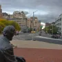Seated Lincoln overlooks a brick-paved plaza toward a city intersection.