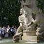 Fountain of the Artichoke with stone figures holding a crest in a pool of water.