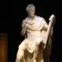 Seated George Washington sculpture in white stone, holding a stylus and tablet, with an information panel beside it.