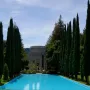 Pulgas Water Temple with a long blue reflecting pool, stone rotunda, and tall evergreen trees lining the avenue.