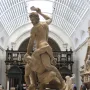 Samson Slaying a Philistine marble sculpture in a museum gallery, with one figure standing over another and raising a club.