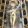Transi of René of Chalon, an emaciated stone figure holding a heart to its chest in a dark niche.